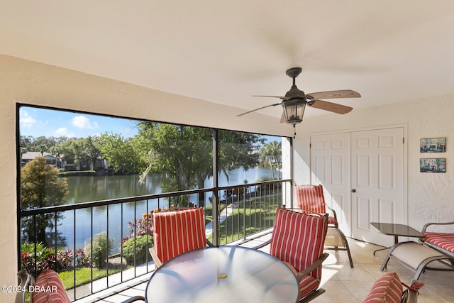 sunroom with a water view and ceiling fan