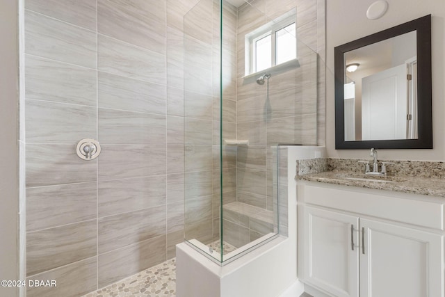 bathroom featuring a tile shower and vanity