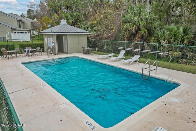 view of swimming pool featuring a patio area and an outbuilding