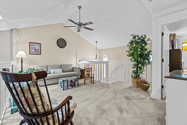 carpeted living room with ceiling fan and vaulted ceiling