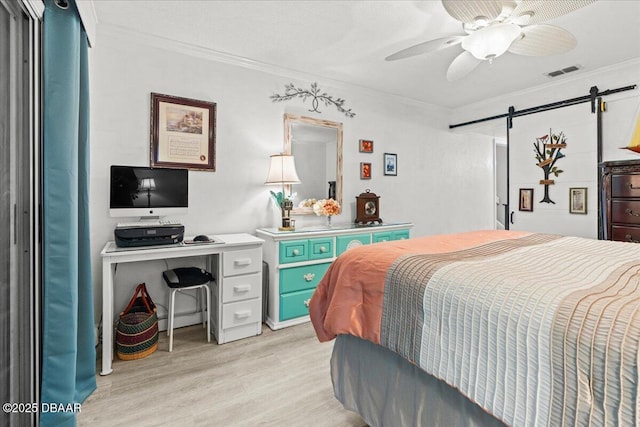 bedroom featuring a barn door, crown molding, ceiling fan, and light hardwood / wood-style floors