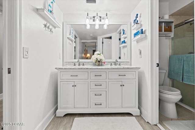 bathroom with vanity, wood-type flooring, a shower with shower door, and toilet