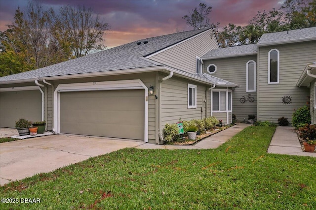 view of front of property featuring a garage and a lawn