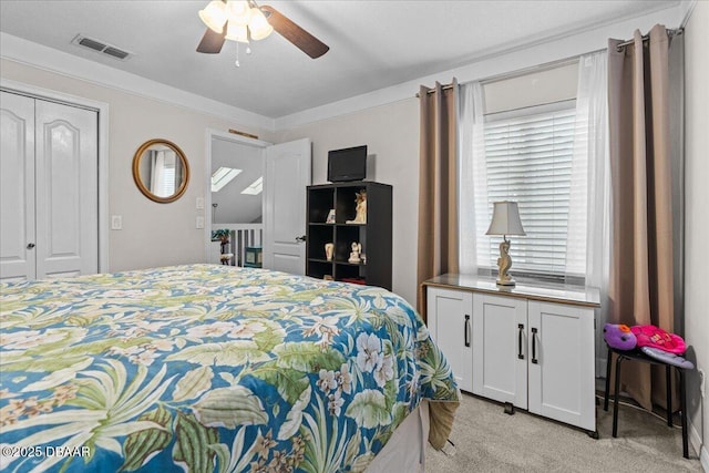 carpeted bedroom with ceiling fan and a closet