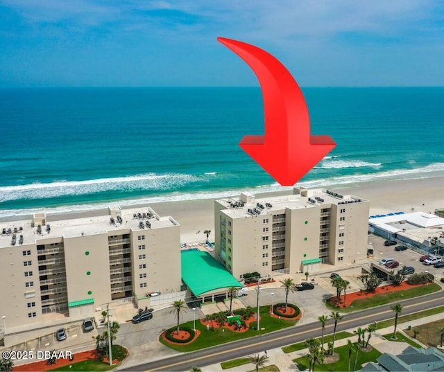 drone / aerial view featuring a beach view and a water view