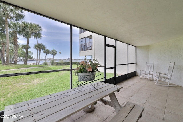 unfurnished sunroom featuring a wealth of natural light and a water view