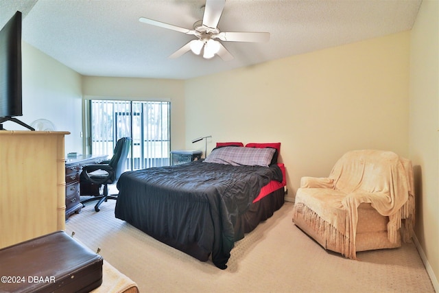 bedroom featuring a textured ceiling, light colored carpet, and ceiling fan