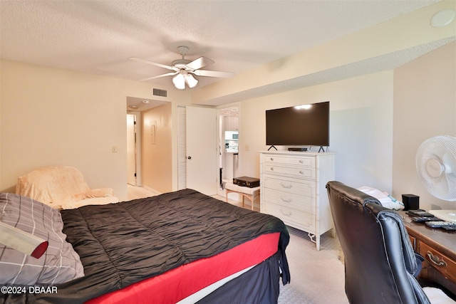 carpeted bedroom featuring a closet, a textured ceiling, and ceiling fan