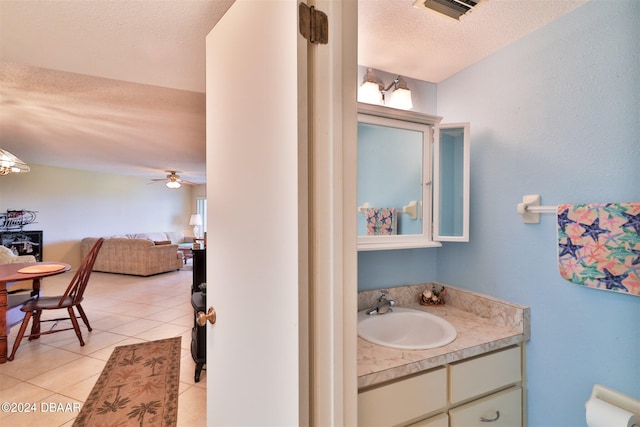 bathroom with a textured ceiling, tile patterned flooring, vanity, and ceiling fan