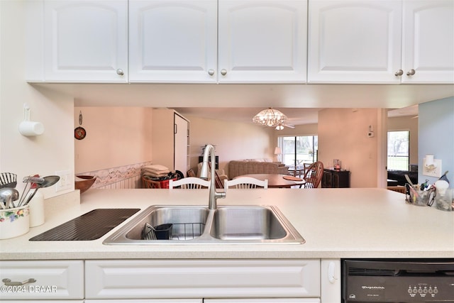 kitchen featuring dishwasher, a chandelier, white cabinets, and sink