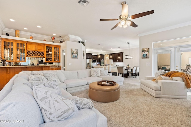 living area featuring ceiling fan, visible vents, ornamental molding, light carpet, and recessed lighting