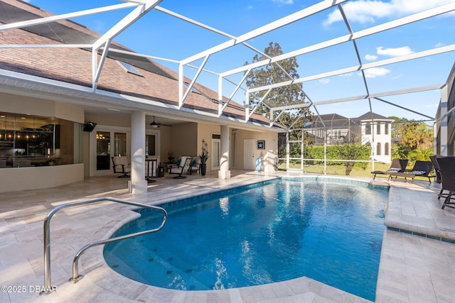 outdoor pool with a ceiling fan, a patio, and glass enclosure