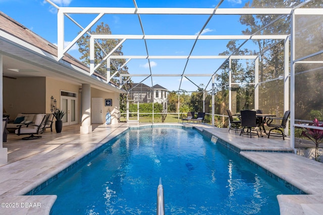 outdoor pool featuring glass enclosure and a patio area