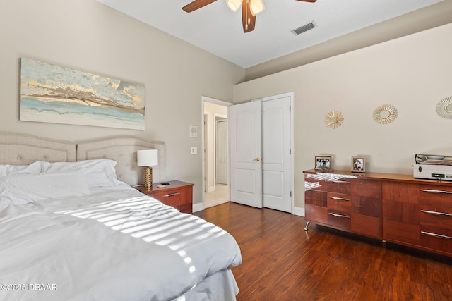 bedroom with visible vents, baseboards, dark wood-type flooring, and ceiling fan
