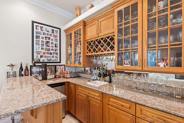 bar featuring stainless steel dishwasher, crown molding, light tile patterned flooring, a sink, and wet bar