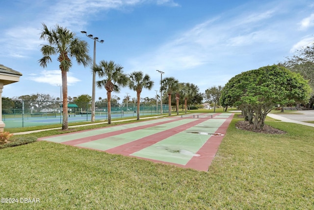 view of community with a lawn and tennis court