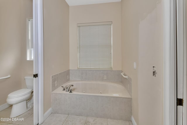 bathroom with tile patterned floors, a relaxing tiled tub, and toilet