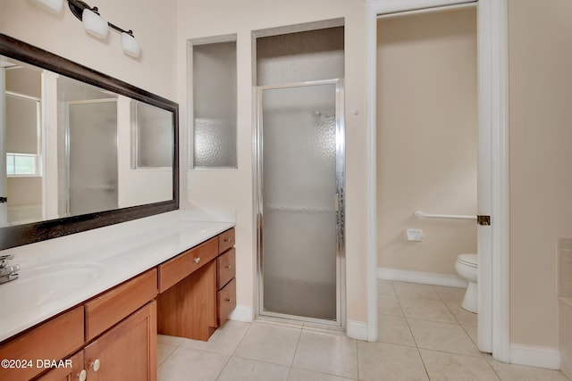 bathroom with tile patterned floors, vanity, a shower with shower door, and toilet