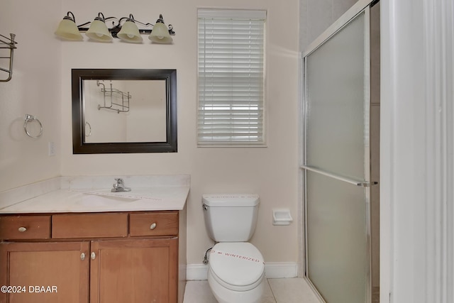 bathroom featuring tile patterned floors, toilet, vanity, and walk in shower