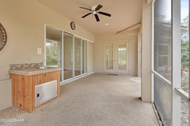 unfurnished sunroom featuring ceiling fan and sink