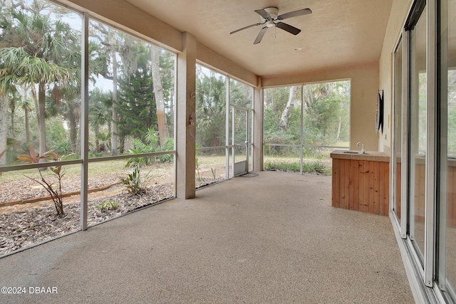 unfurnished sunroom featuring sink, plenty of natural light, and ceiling fan