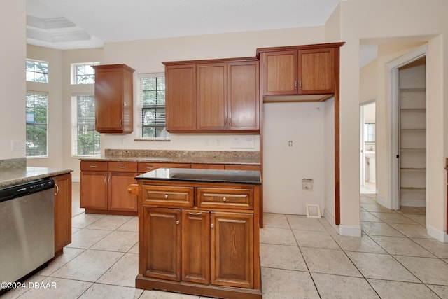 kitchen featuring stainless steel dishwasher, light tile patterned floors, and ornamental molding