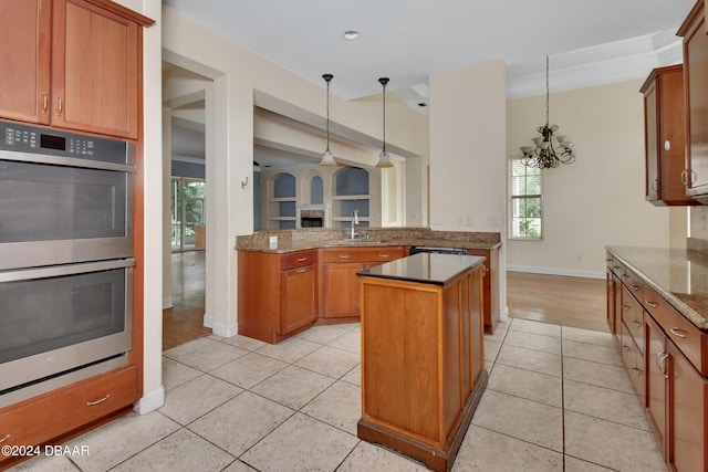 kitchen featuring a notable chandelier, plenty of natural light, stainless steel double oven, and kitchen peninsula