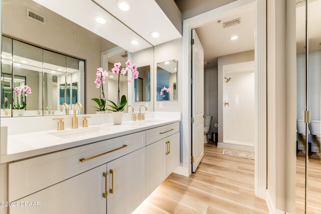 bathroom with hardwood / wood-style flooring, vanity, and toilet