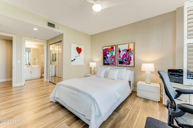 bedroom featuring ensuite bathroom, light hardwood / wood-style floors, and ceiling fan