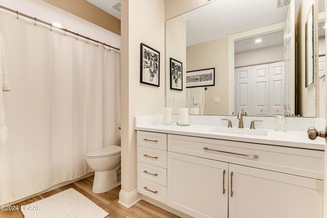 bathroom with hardwood / wood-style flooring, vanity, and toilet