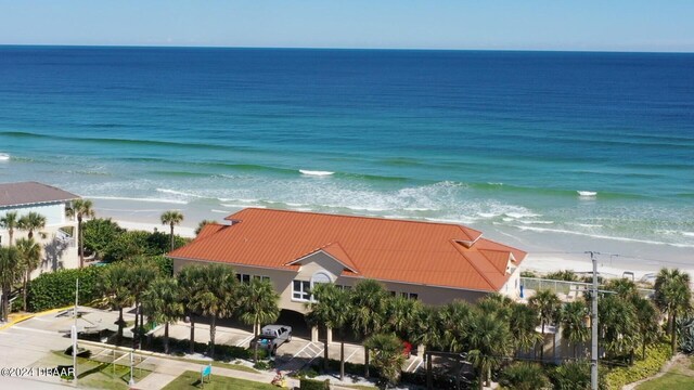 birds eye view of property featuring a beach view and a water view