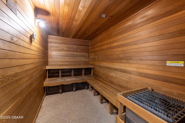 view of sauna with wooden walls, wood ceiling, and tile patterned flooring