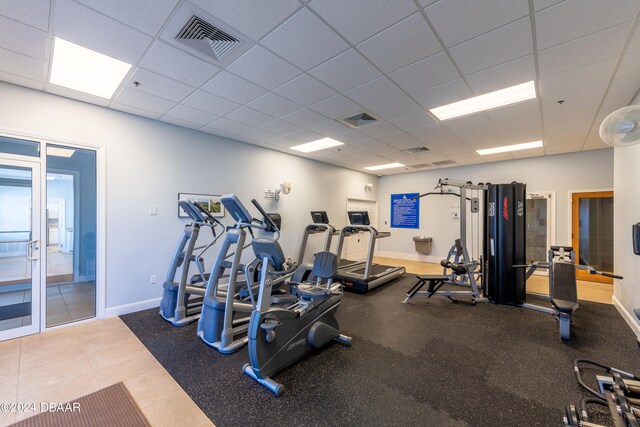 exercise room with tile patterned flooring and a paneled ceiling