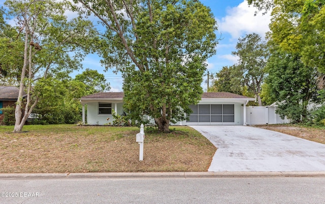 view of property hidden behind natural elements with concrete driveway and stucco siding