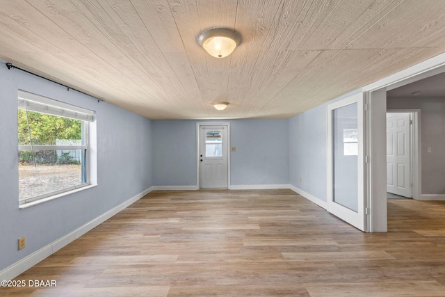 foyer featuring healthy amount of natural light, wooden ceiling, light wood-style flooring, and baseboards