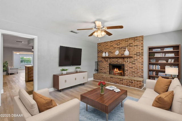 904 Woodmere Cir, Ormond Beach, FL 32174 - living room featuring a ceiling fan, light wood finished floors, and a brick fireplace