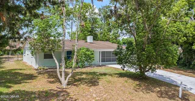 view of front of property with a chimney, driveway, and stucco siding