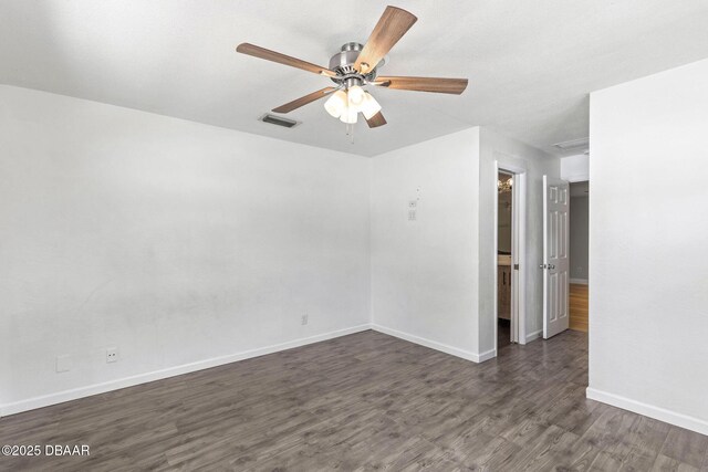empty room featuring dark wood finished floors, baseboards, and a ceiling fan