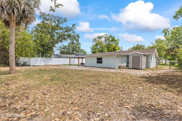 back of property featuring a gazebo, a shed, a fenced backyard, and a patio