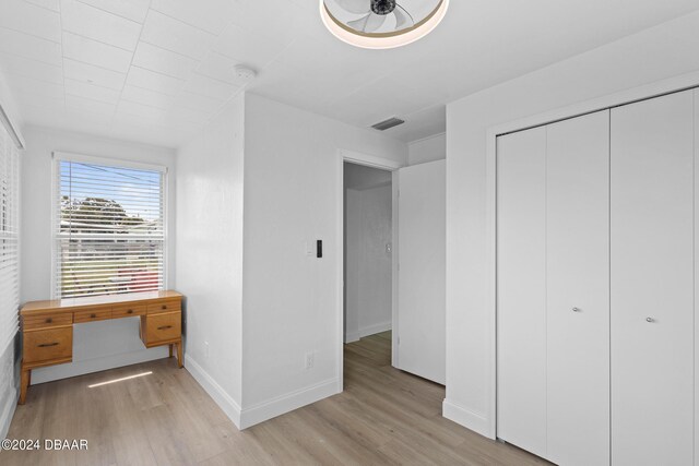 unfurnished bedroom featuring a closet and light wood-type flooring