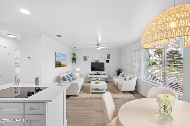 living room featuring light wood-type flooring and ceiling fan