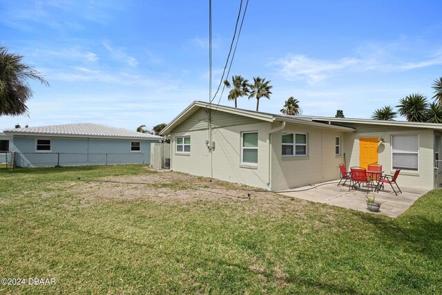 rear view of property with a patio and a lawn