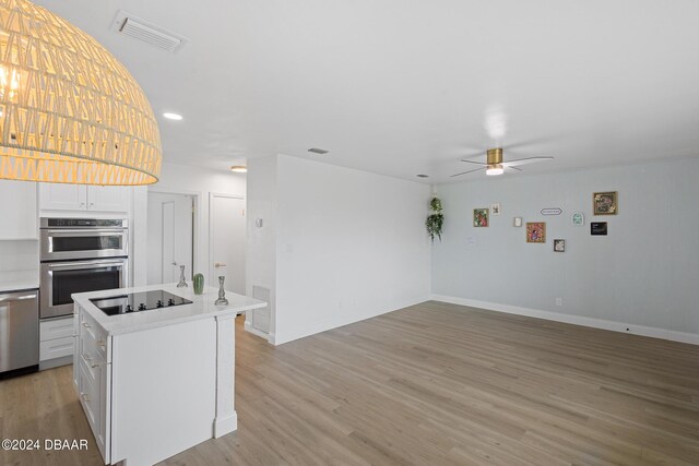 kitchen with a kitchen island with sink, white cabinets, light hardwood / wood-style flooring, ceiling fan, and stainless steel appliances