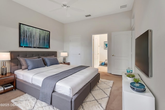 bedroom featuring a ceiling fan, light colored carpet, visible vents, and connected bathroom