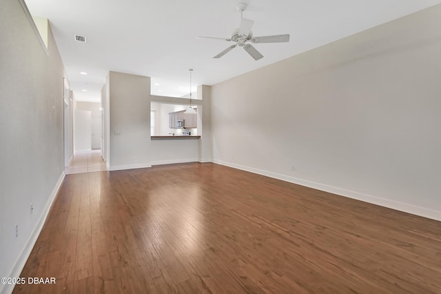 unfurnished living room with dark wood finished floors, recessed lighting, visible vents, a ceiling fan, and baseboards