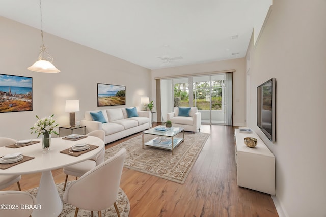 living area featuring light wood finished floors, visible vents, and a ceiling fan