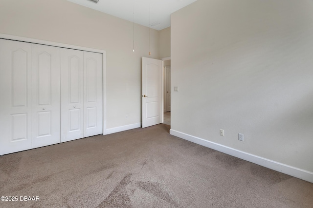 unfurnished bedroom featuring a closet, carpet flooring, and baseboards