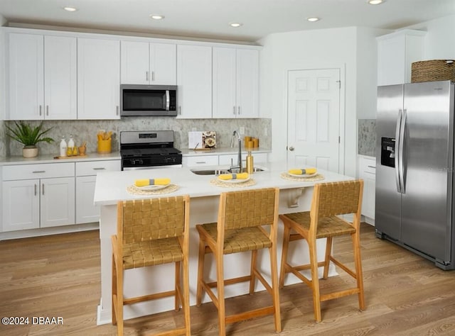 kitchen featuring white cabinetry, light wood-type flooring, stainless steel appliances, and sink