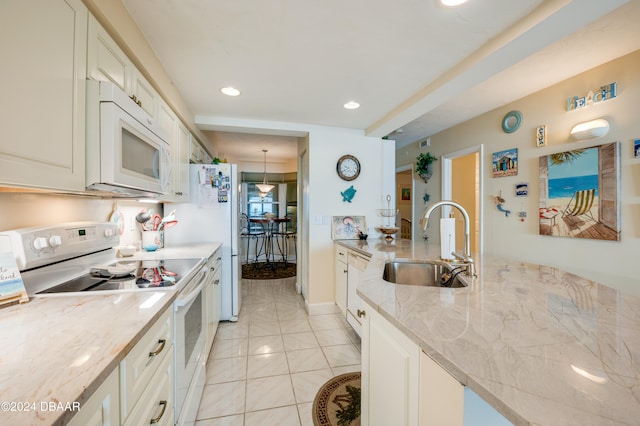 kitchen with white cabinets, sink, white appliances, and light tile patterned floors