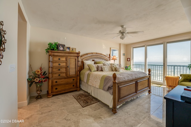 bedroom featuring a water view, ceiling fan, and access to exterior